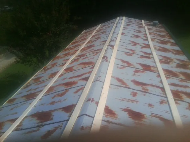 Rusted metal roof panels with new wood purlins before replacement — Storm Damage Roof Repair in Hardyville by Roofing Brothers