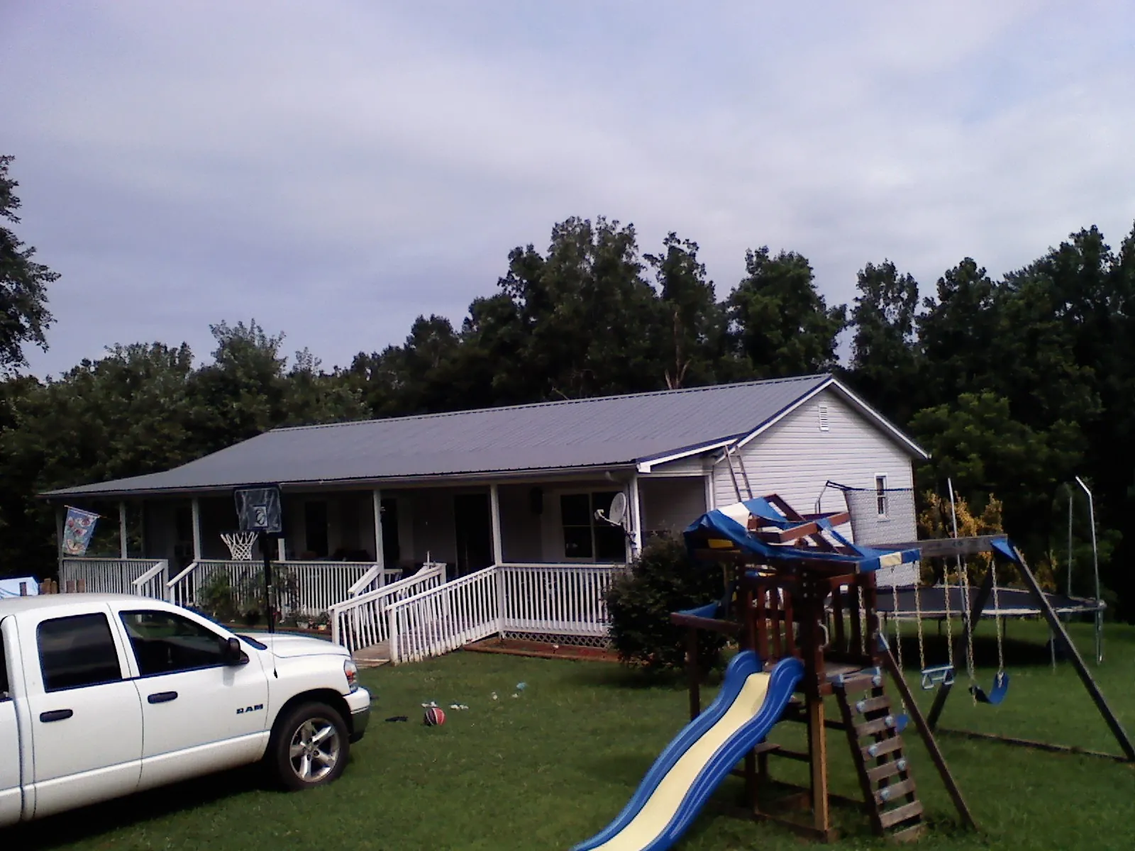 Dark metal roof on a country home with a full length front porch in Hardyville